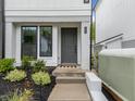Inviting front entrance with a stylish gray door, modern house numbers and lush landscaping at 710 W North St # 101, Raleigh, NC 27603
