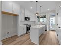Bright, modern kitchen featuring white cabinets, stainless steel appliances, and an island at 710 W North St # 101, Raleigh, NC 27603