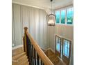 Elegant entryway showcasing a modern chandelier, soaring ceilings, and stylish wood and iron staircase at 80 Water Willow Ln, Zebulon, NC 27597