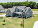 Elegant two-story home boasts lush landscaping and a covered front porch with classic architectural details at 80 Water Willow Ln, Zebulon, NC 27597