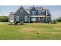 Inviting home featuring a manicured lawn, beautiful landscaping, and a charming covered front porch at 80 Water Willow Ln, Zebulon, NC 27597