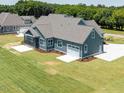 Back of home with screened in porch, well manicured lawn, and a spacious driveway at 80 Water Willow Ln, Zebulon, NC 27597