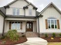 Charming two-story home with wood shutters and an inviting front porch with an elegant wood front door at 90 Water Willow Ln, Zebulon, NC 27597