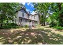 Spacious backyard surrounded by mature trees offering shade and privacy at 903 Nicholas St, Henderson, NC 27536