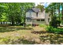 Expansive backyard featuring mature trees, creating a serene and natural environment at 903 Nicholas St, Henderson, NC 27536