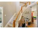 Carpeted staircase with wood railing leads to the upper level at 10205 Sorrills Creek Ln, Raleigh, NC 27614