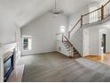 Bright living room showcasing vaulted ceilings, a cozy fireplace, and elegant staircase with a wood banister and white risers at 105 Crosswaite Way, Cary, NC 27518