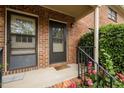 Close up view of the brick entryway, with a black railing, and blooming flowers at 105 Fidelity St # B19, Carrboro, NC 27510