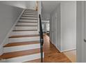 Bright foyer featuring hardwood floors, a staircase with white risers and a black railing at 105 Fidelity St # B19, Carrboro, NC 27510