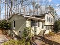 Split-level home showcasing a painted brick facade, complemented by dark shutters and steps leading to dual entry points at 1195 Champion Dr, Cary, NC 27511