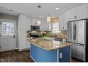 Bright kitchen features white cabinets, stainless steel appliances, a granite island, and stylish pendant lighting at 1195 Champion Dr, Cary, NC 27511