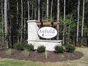 Community sign for Anfield Estates surrounded by verdant landscaping and set amongst mature trees at 121 Anfield Rd, New Hill, NC 27562