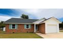 Charming brick home with a well-maintained lawn and attached garage offers curb appeal at 1602 Fairground Rd, Dunn, NC 28334