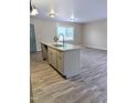 Bright kitchen features gray cabinets, granite counters and a central island with a sink at 1602 Fairground Rd, Dunn, NC 28334