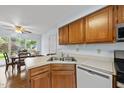 Functional kitchen featuring wood cabinets, stainless steel sink, and a view into the adjacent dining area at 1609 Forest Rd, Wake Forest, NC 27587
