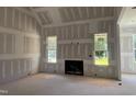 Living room with fireplace framed by two windows and drywall-covered walls and ceilings at 163 Batten Hill Ln, Selma, NC 27576