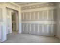 An unfinished living room with newly installed drywall and an open doorway leading to another room at 163 Batten Hill Ln, Selma, NC 27576