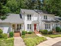 Inviting townhome with a red door, covered porch, and well-maintained front yard at 166 Greenmont Ln, Cary, NC 27511