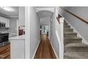 Hallway featuring hardwood floors, gray walls, and leading to a staircase at 166 Greenmont Ln, Cary, NC 27511