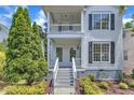 Beautifully landscaped two-story home featuring a double porch with white trim and dark shutters at 2204 Bellaire Ave, Raleigh, NC 27608