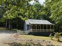 Charming home with a covered porch, nestled among lush trees for a private and peaceful setting at 225 Meadow Dr, Henderson, NC 27537