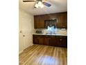 Another view of the charming kitchen featuring plentiful cabinets, laminate floors, and a stainless steel microwave at 225 Meadow Dr, Henderson, NC 27537