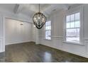 Elegant dining room featuring wainscoting, hardwood floors, a modern chandelier, and plenty of natural light at 2309 Redbridge Ln, Apex, NC 27502