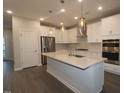 A modern eat-in kitchen features stainless steel appliances, quartz countertops, and pendant lighting at 2733 Hunter Woods Dr # 570, Apex, NC 27502