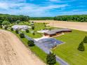 An aerial view showcases the home, pond, and surrounding fields with an ample front yard and long driveway at 3187 Wilsons Mills Rd, Smithfield, NC 27577