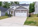 Attractive home featuring a wide driveway, manicured lawn, and a stone-accented two-car garage at 389 Whetstone Dr, Angier, NC 27501