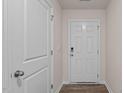Bright entryway featuring a white front door, light walls, and wood-look flooring; next to a closed interior door at 552 Stream Walk Xing, Wendell, NC 27591