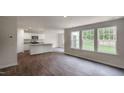 Open-concept living room and kitchen with hardwood floors and abundant natural light at 560 Stream Walk Xing, Wendell, NC 27591