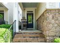 Inviting front porch with brick steps, a seating area, and stone accents on the home's facade at 5638 Wade Park Blvd, Raleigh, NC 27607