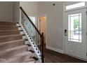 Elegant staircase with carpeted steps, dark wood handrail, and decorative metal balusters at 5638 Wade Park Blvd, Raleigh, NC 27607