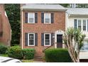 Charming brick townhouse with black shutters, offering a welcoming facade and a well-maintained front yard at 6225 Waterside Ln, Raleigh, NC 27613