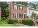 Charming brick townhouse with black shutters, offering a welcoming facade and a well-maintained front yard at 6225 Waterside Ln, Raleigh, NC 27613