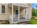 Welcoming front porch with classic white railings and a blue front door at 7404 Halifax Rd, Youngsville, NC 27596
