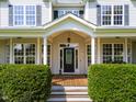 Inviting front porch with wood deck features and manicured hedges leading to the front door at 80 Shambley Meadows Dr, Pittsboro, NC 27312