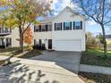 Inviting two-story home with a spacious driveway, complemented by mature trees and manicured landscaping at 821 Stackhurst Way, Wake Forest, NC 27587
