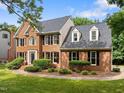A stately brick-sided home with well-manicured lawn at 100 Silver Lining Ln, Cary, NC 27513