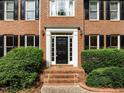 Close-up of the front door with brick steps and manicured bushes and shrubs at 100 Silver Lining Ln, Cary, NC 27513