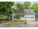 Inviting two-story home with a manicured lawn, a three-car garage, and classic white siding at 104 Edgewater Cir, Chapel Hill, NC 27516