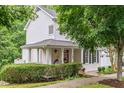 Inviting white home with a charming front porch featuring hanging flower baskets and stylish egg chairs at 104 Edgewater Cir, Chapel Hill, NC 27516
