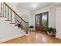 Elegant foyer with hardwood floors, staircase with iron railings, and a stylish entry door at 119 Eagles Watch Ln, Chapel Hill, NC 27517