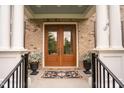 Elegant double front doors are framed by white pillars, enhancing curb appeal at 119 Eagles Watch Ln, Chapel Hill, NC 27517