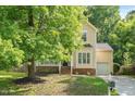 Charming two-story home with manicured lawn and lush, mature tree in front yard at 121 River Hills Dr, Clayton, NC 27527
