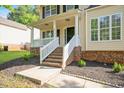 Inviting front porch with white railings and brick base and beautifully landscaped garden at 121 River Hills Dr, Clayton, NC 27527