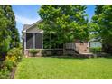 A screen porch in a backyard featuring a well-maintained lawn and mature trees at 1218 Crystalwater Dr, Fuquay Varina, NC 27526