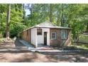Charming exterior with brick, white siding, and a covered entrance surrounded by lush greenery at 126 Barclay Rd, Chapel Hill, NC 27516