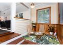 Cozy sunroom with wood paneling, a lush fern rug, and stylish wooden chairs at 126 Barclay Rd, Chapel Hill, NC 27516